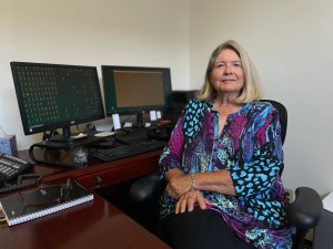 Carolyn Hamby sits at her desk, facing the camera.